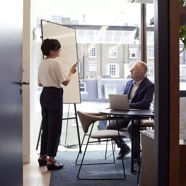 Coworkers using whiteboard to discuss Conga's Automate Revenue Suite