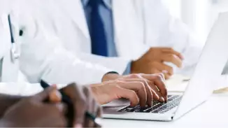 Doctor typing on laptop