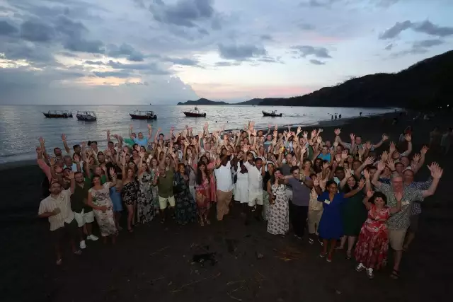 Conga employees waving on a beach