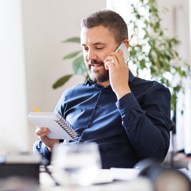 Man talking on phone about benefits of Conga's Commercial Operations Suite
