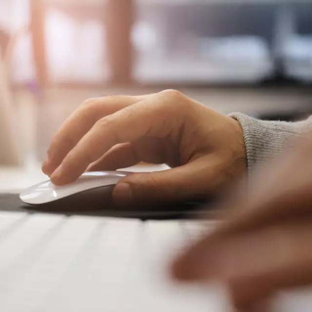 Closeup of hands on keyboard and computer mouse