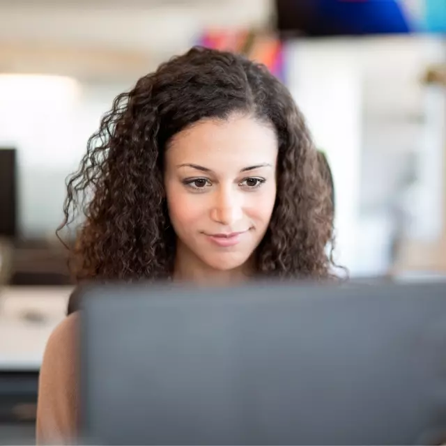 Woman smiling looking at laptop