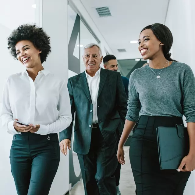 Coworkers smiling and walking in office
