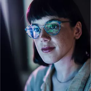 Woman wearing glasses reflecting AI on screen